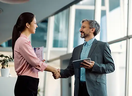 A hiring manager welcoming a candidate with a handshake